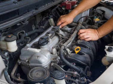 Otomatik onarım hizmetinde çalışan araba tamircisi. Ve araba tamircisi elinde araba motoru tamir