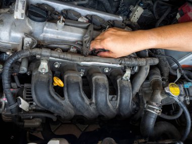Otomatik onarım hizmetinde çalışan araba tamircisi. Ve araba tamircisi elinde araba motoru tamir