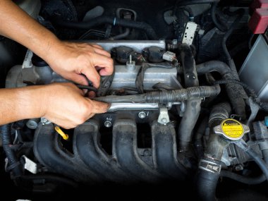 Otomatik onarım hizmetinde çalışan araba tamircisi. Ve araba tamircisi elinde araba motoru tamir