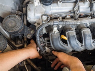 Otomatik onarım hizmetinde çalışan araba tamircisi. Ve araba tamircisi elinde araba motoru tamir
