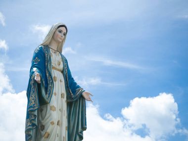 The Blessed Virgin Mary Statue blue sky background. clipart