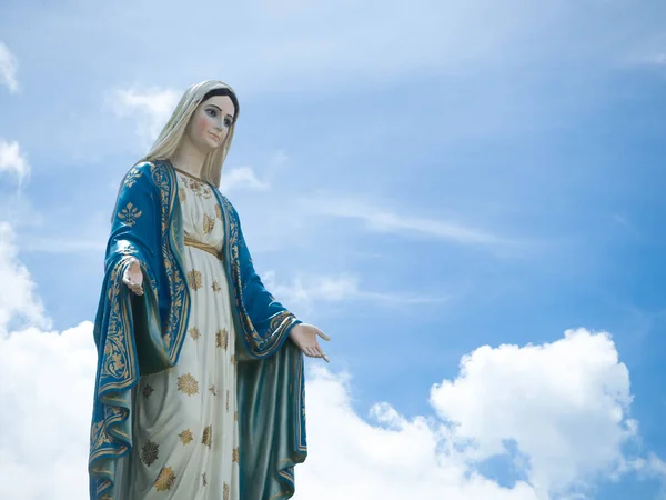 Jungfru Maria statyn blå himmel bakgrund. — Stockfoto