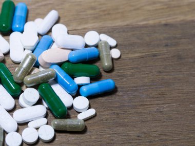 Uyuşturucu ve kapsül olduğunu ahşap masa necklac ilaç ve uyuşturucu kapsül.