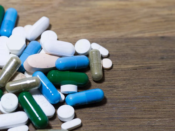 Uyuşturucu ve kapsül olduğunu ahşap masa necklac ilaç ve uyuşturucu kapsül.