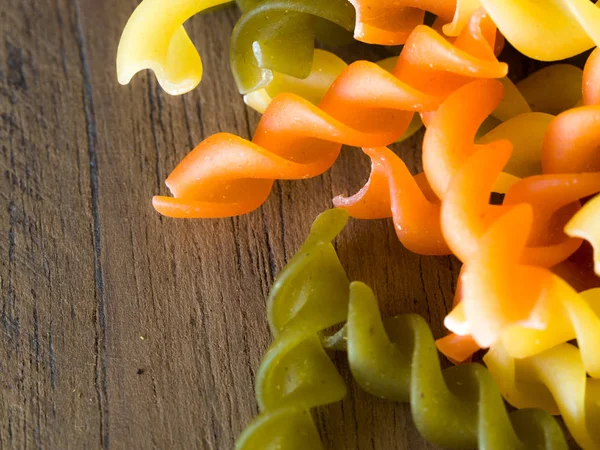 Arka plan renkli makarna doku yakın çekim. ahşap bir masa üzerinde kurutulmuş bir İtalyan makarna kapatın. Renkli doğal makarna