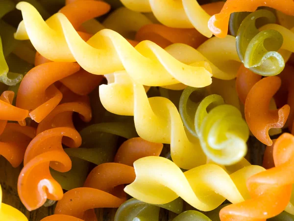 Arka plan renkli makarna doku yakın çekim. ahşap bir masa üzerinde kurutulmuş bir İtalyan makarna kapatın. Renkli doğal makarna