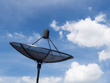 Evin çatı mavi gökyüzü bulutlu arka plan üzerinde siyah uydu çanağı veya Tv antenleri yükleyin.