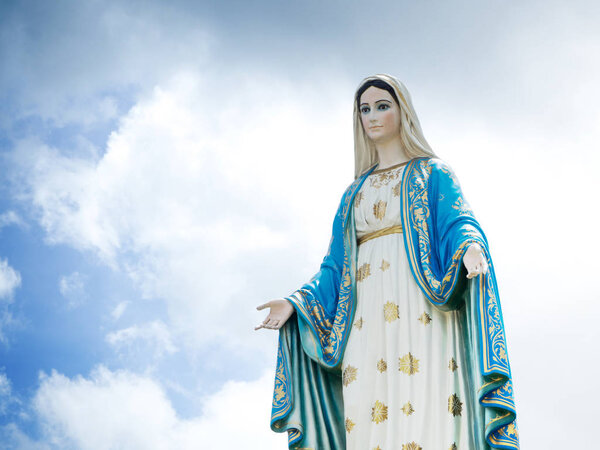 The Blessed Virgin Mary Statue blue sky background.