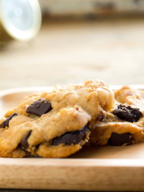 Çerezler kadar çikolata ve fıstık ile kapatın. Ahşap bir tabağa yerleştirilmiş. Eski saat döndü. Kahve fren kavramı.