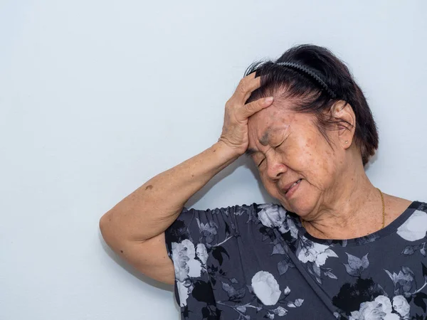 Mulher idosa sofrendo e cobrindo rosto com as mãos em dor de cabeça e depressão profunda. desordem emocional, luto e desespero conceito — Fotografia de Stock