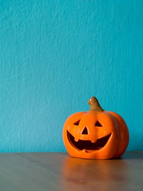 Ahşap masa üzerinde Halloween Kabak kafa. mavi ve boşaltmak metin için arka plan olduğunu