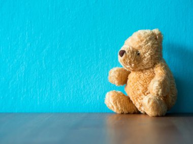 Ahşap masanın üzerinde kahverengi ayıcık. Turkuaz ve kopya alanıdır içerik için arka plan