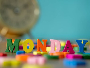 Renkli ahşap ahşap masa ve vintage çalar saat ve arka plan Pazartesi toz mavi kelimedir. İngilizce alfabe ahşap mektup rengini yapılan.