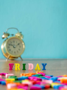 Renkli ahşap Cuma günü ahşap masa ve vintage çalar saat ve arka plan açık mavi bir kelimedir. İngilizce alfabe ahşap mektup rengini yapılan.