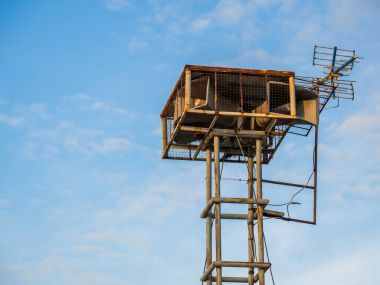 Eski halk hoparlörleri yüksek kulede mavi gökyüzü arka planında vintage yayın yapıyor.