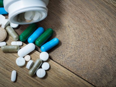 Necklac ilaç ve kapsül üzerinde ahşap tablodur. Portre. Uyuşturucuya karşı olduğumuzu sağlık için kapsayıcısında (ilaçlar), tedavi. Yeşil mavi beyaz yuvarlak kapsül hap ilaç antibiyotik ile yığını