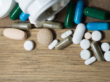 Necklac ilaç ve kapsül üzerinde ahşap tablodur. Portre. Uyuşturucuya karşı olduğumuzu sağlık için kapsayıcısında (ilaçlar), tedavi. Yeşil mavi beyaz yuvarlak kapsül hap ilaç antibiyotik ile yığını