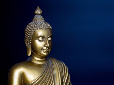 Altın antika Buda heykeli. Arka plan gece mavisi olduğunu. Buda'nın yüzü sola dönük.