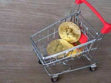 Altın bitcoin cryptocurrency Resepsiyon ahşap arka plan üzerinde kırmızı alışveriş arabası. Dijital para cryptocurrency kavramı.