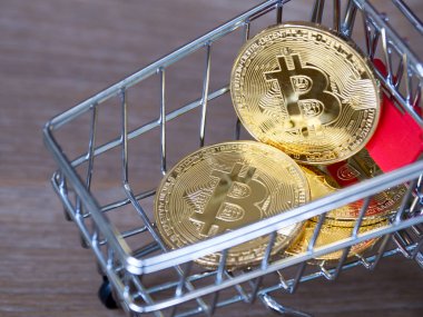 Altın bitcoin cryptocurrency Resepsiyon ahşap arka plan üzerinde kırmızı alışveriş arabası. Dijital para cryptocurrency kavramı.