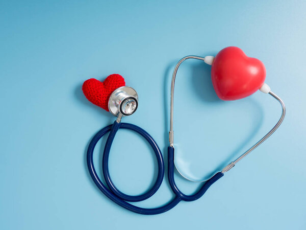 red heart using deep blue stethoscope on the blue background for hear their other heart. Concept of love and caring patient by the heart. Copy space for the text and contents