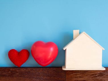 Kırmızı kalp ile mavi arka plan (izole) üzerinde ahşap ev. metin ve içerik için alan kopyalayın. Aşk ve aile kavramı