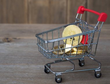 Altın bitcoin cryptocurrency Resepsiyon ahşap arka plan üzerinde kırmızı alışveriş arabası. Dijital para cryptocurrency kavramı.