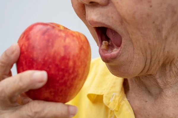 Una Anciana Lleva Gafas Sin Dientes Tratando Comer Manzanas Rojas — Foto de Stock
