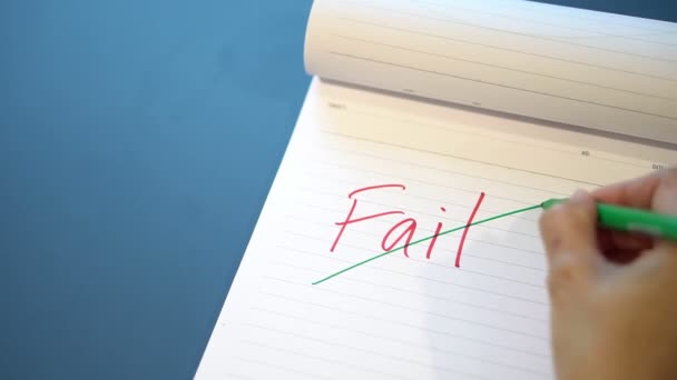 Fild text with a hand with a red pen And crossed out with a green pen on the notebook. Success message by hand with a green pen below the fail. The concept of ​​not giving up on failure. — Stock Video