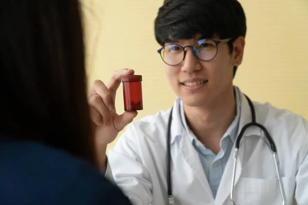 Asijský Doktor Stetoskopem Uniformou Držící Lahvičku Léky Vysvětluje Léčivé Vlastnosti — Stock fotografie