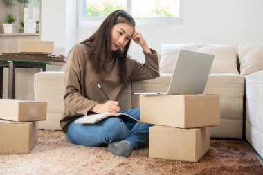 Genç Asyalı girişimci dizüstü bilgisayarla müşterilerin siparişlerini kontrol ettikten sonra satışların azalmasından kaynaklanan stres ve endişe duyuyor. Küçük işletme sahibi kavramı. Bir iş danışmanına ihtiyacım var.