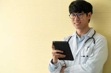 Genç Asyalı doktorlar hastaların sağlık muayenesi için bilgi ve verileri kontrol etmek için tablet kullanıyorlar. Dijital, teknoloji ve tıbbi iletişim kavramı.