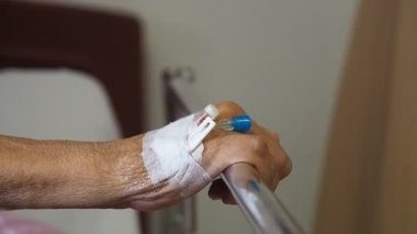 El hasta yaşlı adam el hastanede serum fizyolojik intravenöz (IV) çözüm ile kapatın. hasta ile iğne tak tıp için serum fizyolojik ile kullanmak için.