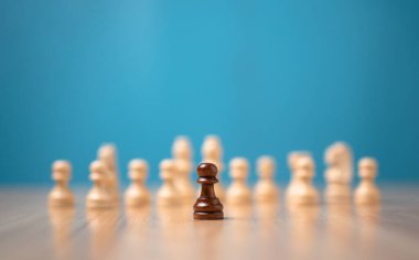 Kahverengi satranç oyuncusu beyaz satrancın önünde duruyor, yeni bir girişim kavramı iş oyunlarında kazanmak için cesaret ve meydan okumaya sahip olmalıdır.