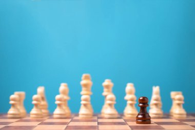 Kahverengi satranç oyuncusu beyaz satrancın önünde duruyor, yeni bir girişim kavramı iş oyunlarında kazanmak için cesaret ve meydan okumaya sahip olmalıdır.