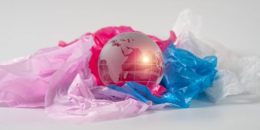 The crystal globe on plastic bag. Plastic waste overflows the world. Global Warming and Climate Change concept. clipart