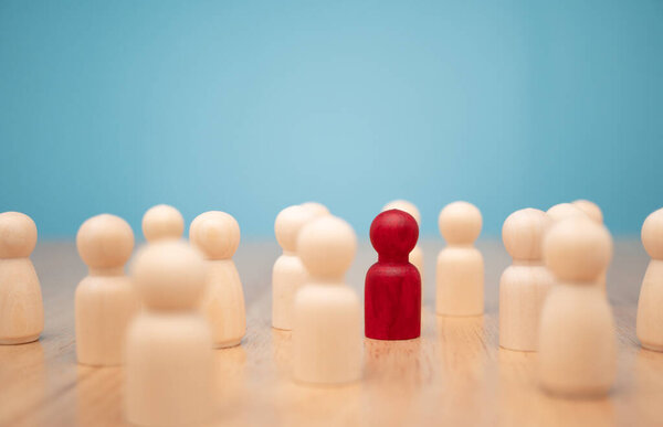 Деревянная фигура, стоящая с командой, чтобы показать влияние и силу. Концепция бизнес-лидерства для команды лидеров, успешного победителя конкурса и лидера с влиянием
