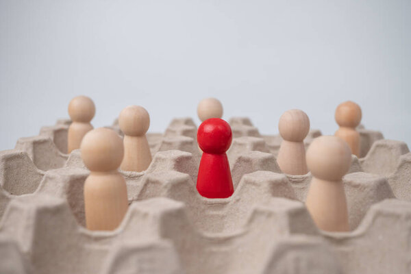 Деревянная фигура, стоящая вместе с командой для влияния и расширения прав и возможностей. Концепция лидерства, успешный победитель конкурса и Лидер с влиянием и социальным дистанцированием для нового нормального образа жизни