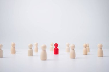 Etkilemek ve güçlendirmek için bir ekiple birlikte duran tahta bir figür. Liderlik kavramı, başarılı yarışma galibi ve yeni normal bir yaşam tarzı için nüfuzlu ve sosyal mesafeli lider.