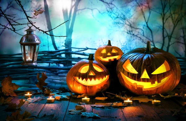 Halloween-Kürbisse auf Holz vor nächtlichem Gruselwald — Stockfoto
