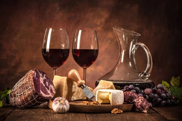 Натюрморт с вином, сыром и сосисками — стоковое фото