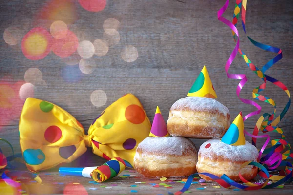 Donuts de carnaval com streamers de papel e laço de festa — Fotografia de Stock