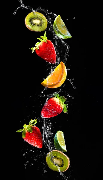 Frutas frescas que caen en agua salpicada — Foto de Stock