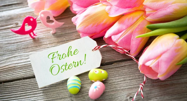 Tulips with an empty tag on wooden background — Stock Photo, Image