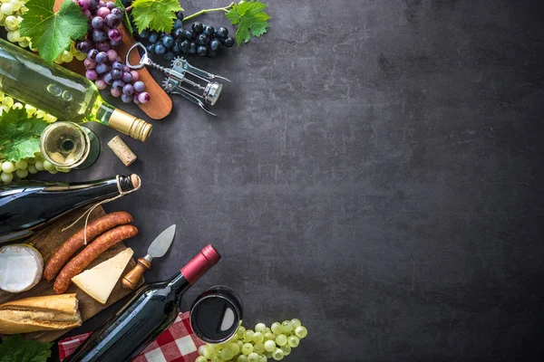 Lahví vína s hrozny, sýr, šunka a zátky — Stock fotografie