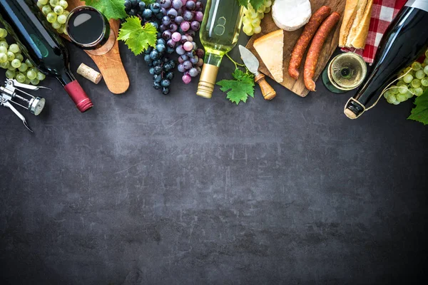 Botellas de vino con uvas, queso, jamón y corcho — Foto de Stock