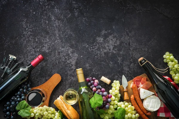 Borosüvegek, szőlő, sajt, sonka és dugók — Stock Fotó
