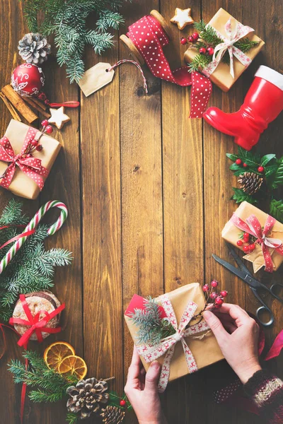 Kobiecych rąk Zawijanie Bożego Narodzenia prezenty świąteczne ręcznie robione w craft papier i wstążki — Zdjęcie stockowe
