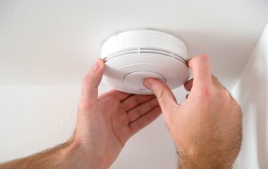 Man installing smoke detector clipart