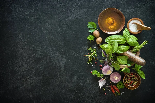 Herbs and spices on black stone table — Stock Photo, Image
